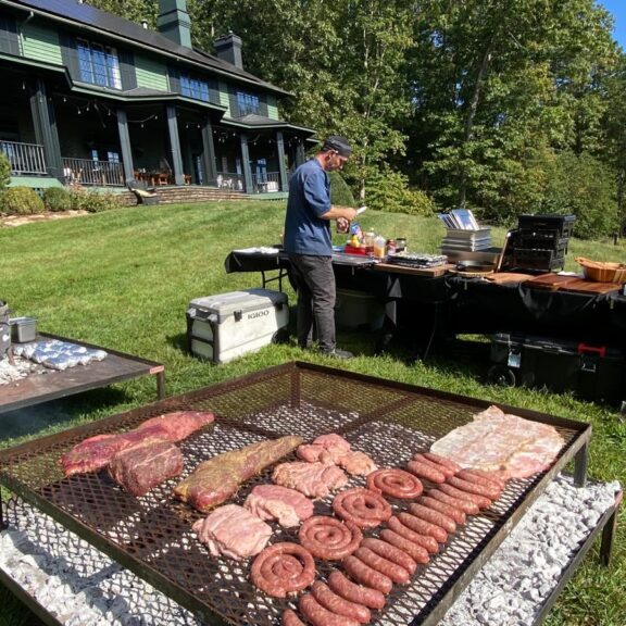 A traditional spread of Argentine imported cuts and 'achuras' on a custom charcoal grill.